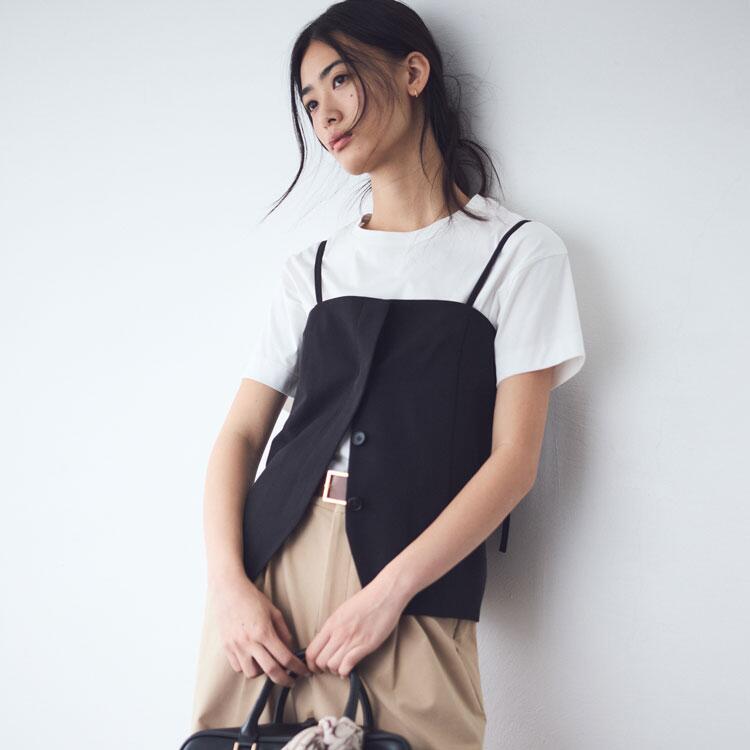 コムサイズム　白いTシャツに黒いビスチェ、ベージュのズボンを履いた女性の写真