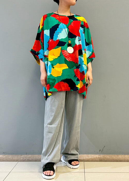 アールシーキャット　カラフルなTシャツにグレーのズボンを履いた女性の写真