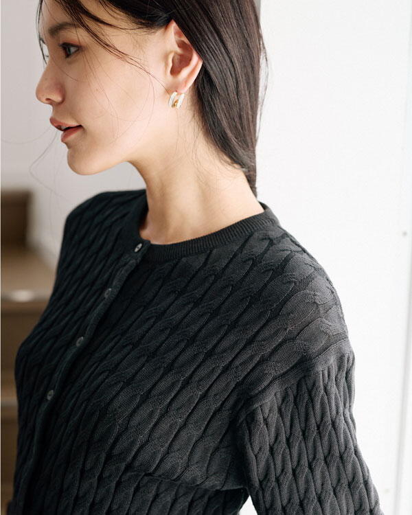 コムサイズム　黒いカーディガンにカーキのスカートを履いた女性の写真